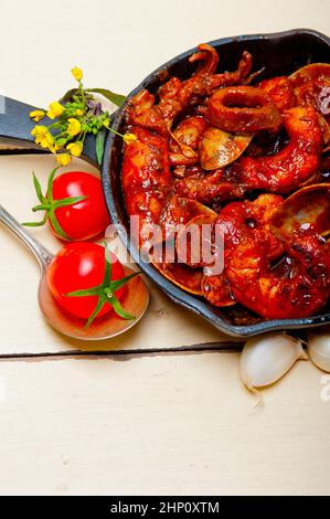 frische Meeresfrüchte-Eintopf zubereitet auf eine eiserne Pfanne Ove weißen rustikalen Holztisch Stockfoto