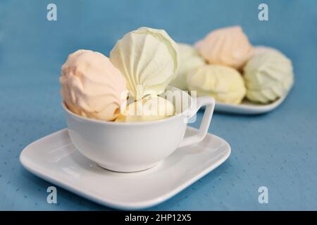 Auf einem gewarteten Tisch in Untertassen liegt köstlicher frischer, farbenfroher Luftmarschall Stockfoto