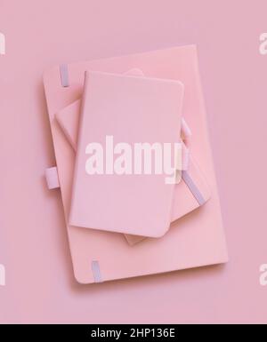 Stapel rosa Notizbücher in hellrosa Draufsicht. Textbuch-Modell, Planercover mit Platztext. Bildungs-, Geschäfts- und Organisationskonzept Stockfoto