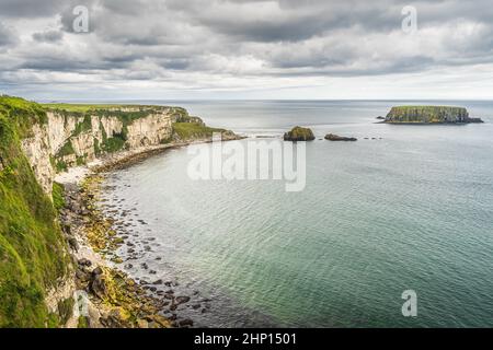 Küste mit hohen Kalksteinfelsen, Sheep Island und türkisfarbenem Atlantischen Ozean, in der Nähe der Carrick a Rede-Hängebrücke, Wild Atlantic Way, Nordirland Stockfoto