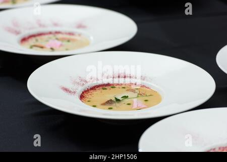 Fischsahnesuppe mit Lachs, Käse und Kräutern in weißen Suppenschüsseln Stockfoto
