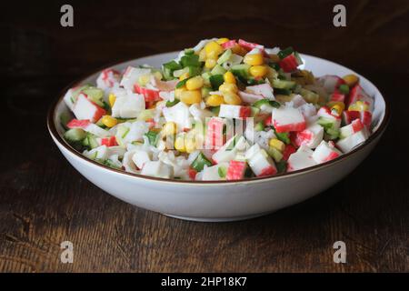 Vegetarischer nahrhafter Salat. Gesunder Fitnesssalat mit Krabbenstäbchen, Mais, Gurke und Reis. Stockfoto