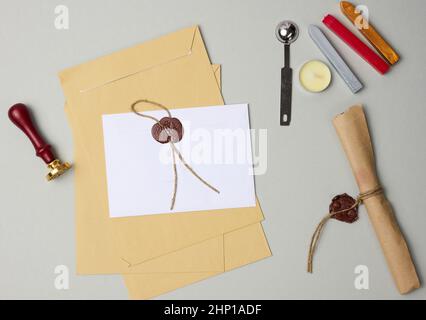 Versiegelter weißer Umschlag mit braunem Wachssiegel auf beigem Hintergrund Stockfoto