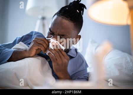 Afrikanischer Amerikanischer Mann Bläst Nase Niesen Im Bett Stockfoto