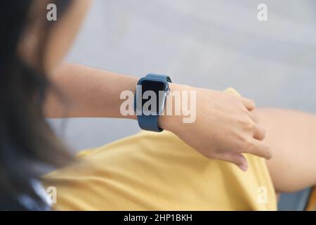 Eine Frau, die auf ihre Smartwatch schaut Stockfoto