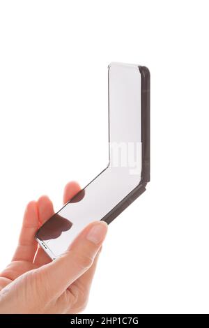 BRATISLAVA, SLOWAKEI - 29. September 2021: Faltbare Samsung Handys Galaxy Z Flip3 in weiblicher Hand isoliert auf weißem Hintergrund. Stockfoto