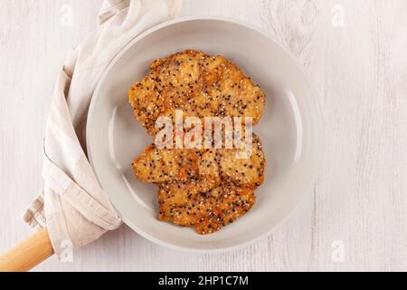 Knuspriger weiner Schnitzel mit Sesamsamen in einer Pfanne von oben. Gebratenes Hühnchen-Steak. Stockfoto