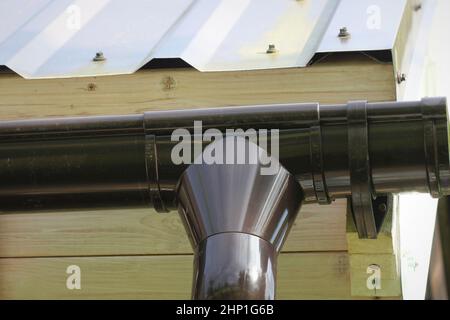 Installation Des Regenrinne-Rohrleitungssystems. Dachkonstruktion. Regenrinne System und Dachschutz vor Schnee. Hausrinnen, Dachrinnen, Dachrinnen Stockfoto