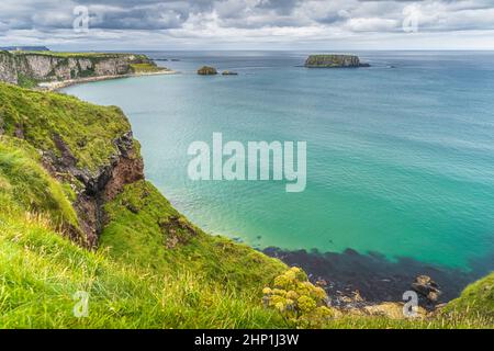 Küste mit hohen Kalksteinfelsen, Sheep Island und türkisfarbenem Atlantischen Ozean, in der Nähe der Carrick a Rede-Hängebrücke, Wild Atlantic Way, Nordirland Stockfoto