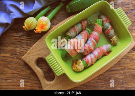 Gegrillte Zucchini-Pommes frites in einem Speck eingewickelt. Stockfoto