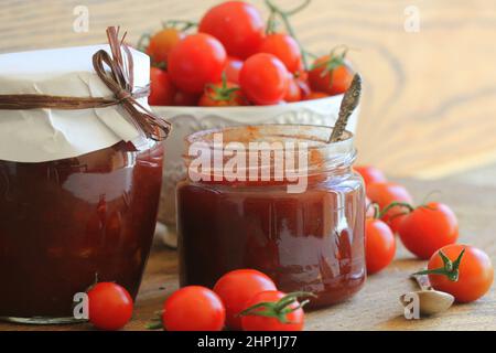 Kirschtomate und Chili Marmelade konserviert in einem Glas. Stockfoto