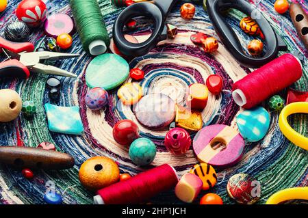 Viele helle Perlen verschiedener Art für Nadelarbeit. Perlen auf einem bunten Hintergrund. Stockfoto