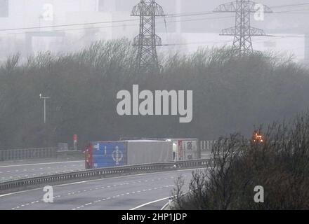 Zwei Lastkraftwagen, die bei starken Winden auf ihre Seite geblasen wurden und die M4 in Margam, Südwales, schließen, als der Sturm Eunice die Südküste trifft, wobei die Attraktionen schließen, die Reise gestört wird und in einigen Gebieten ein größerer Vorfall ausgerufen wird, was bedeutet, dass die Menschen gewarnt werden, im Haus zu bleiben. Eine seltene rote Wetterwarnung - die höchste Warnung, was bedeutet, dass ein hoher Aufprall sehr wahrscheinlich ist - wurde vom Met Office aufgrund der Kombination aus hohen Gezeiten, starken Winden und Sturmfluten ausgegeben. Bilddatum: Freitag, 18. Februar 2022. Stockfoto