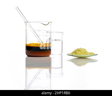 Natriumsulfid-Flocke in chemischem Uhrenglas, eisenhaltige Chlorid-Flüssigkeit mit Rührstab und kristallklare Flüssigkeit im Becher. Chemische Zutat aus der Nähe Stockfoto