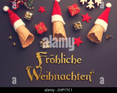 Weihnachtsgeschenkboxen fallen aus einem Eiskegel, der mit dem Weihnachtshut verziert ist, deutsche Worte Frohe Weihnachten Stockfoto