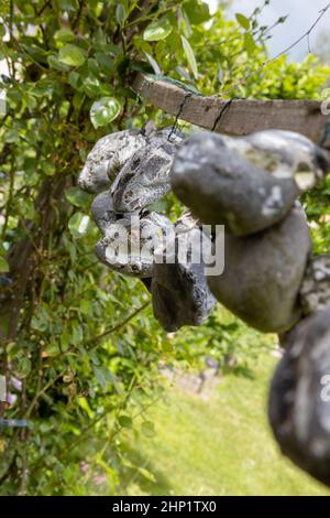 Im Sommer hängen Steine oder Hühnergötter an einem Seil an der frischen Luft Stockfoto