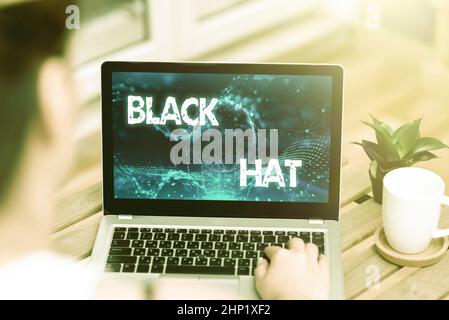 Text mit Inspiration Black hat, Konzept Bedeutung, die in Bezug auf eine schlechte Person verwendet wird, insbesondere eine Bösewichtin oder kriminelle Frau, die auf dem Laptop neben C tippt Stockfoto