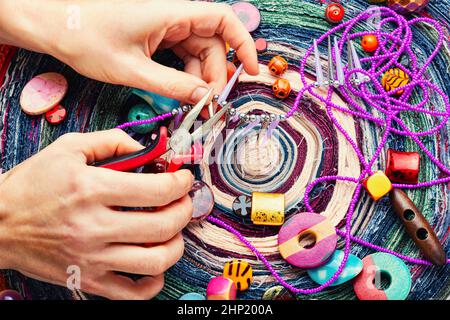Perlen verschiedener Art für Nadelarbeit. Perlen auf einem bunten Hintergrund. Stockfoto