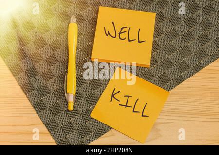 Textschild mit Well Kill, Wort, geschrieben nach der Operation, eine Säule schwerer Flüssigkeit in eine Bohrung mit mehreren Assorted Collection Office Station zu legen Stockfoto