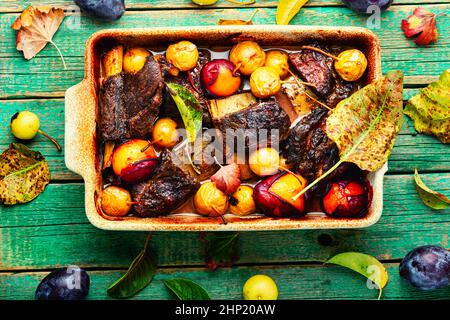 Rinderrippen, gegrillt mit Pflaumen und Birnen in Backform.Fleischrippen in Obstsoße gebraten.Draufsicht Stockfoto