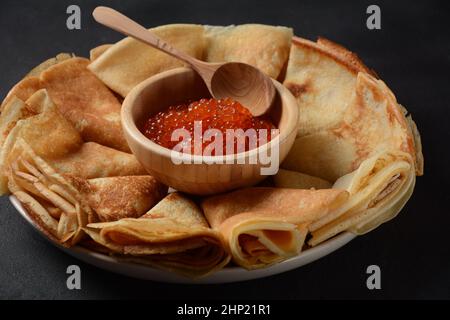 Pfannkuchen mit rotem Kaviar. Fastnacht-Maslenitsa-Woche-Festessen. Stapel russischer Pfannkuchen mit rotem Kaviar. Rustikaler Stil Stockfoto