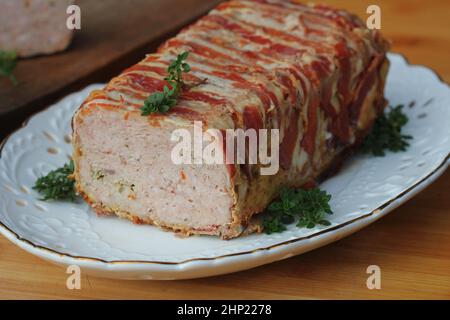 Hackbraten in Speck mit Kräutern eingewickelt. Stockfoto