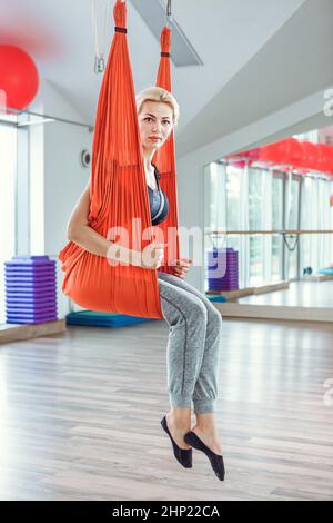 Yoga Fliegen. Junge Frau Praktiken Anti-schwerkraft-Yoga mit einer Hängematte. Stockfoto