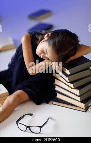 Cute müde Kind Mädchen im blauen Kleid schlafen auf, Bücher zu lesen. Kinder und Bildung. Stockfoto