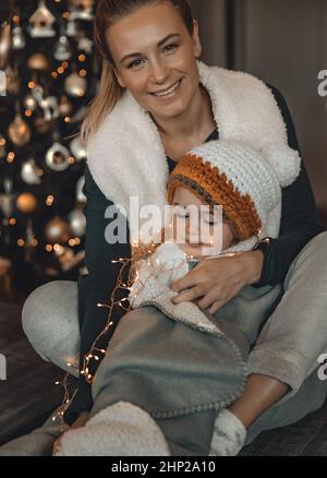 Liebende Mutter genießt Weihnachten mit ihrem schönen Baby. Glückliche Familie Dekorieren Haus für Winterferien Feiern. Vorbereitung auf Weihnachten. Frohes neues Jahr. Stockfoto