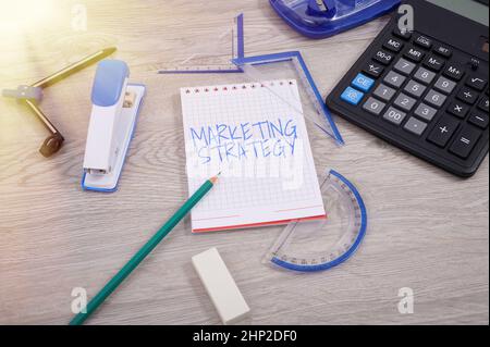 Inspiration showing sign Marketing Strategy, Word for Scheme on How to Layout Products Services Business Blank Notebook Page with A Calculator and Ge Stockfoto