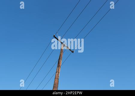 Kabel von elektrischen Leitungen gegen blauen Himmel Stockfoto