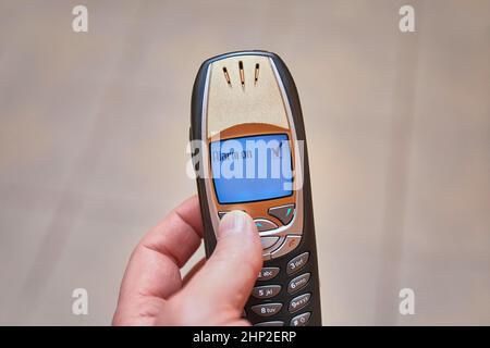 Einstellen des Weckers auf einem alten Mobiltelefon Stockfoto