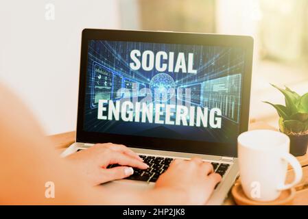 Handschriftentext Social Engineering, Word für psychologische Manipulation Zugang durch Betrug Handeingabe auf dem Laptop neben Kaffeebecher und Plant WOR Stockfoto
