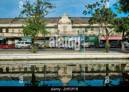 Malerische alte Lagerhäuser und Geschäfte säumen die Atsadang Road entlang des Klong (Kanal) Lod im historischen Stadtgebiet von Bangkok, Thailand, die sich im Wasser spiegeln Stockfoto