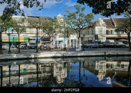 Malerische alte Lagerhäuser und Geschäfte säumen die Atsadang Road entlang des Klong (Kanal) Lod im historischen Stadtgebiet von Bangkok, Thailand, die sich im Wasser spiegeln Stockfoto