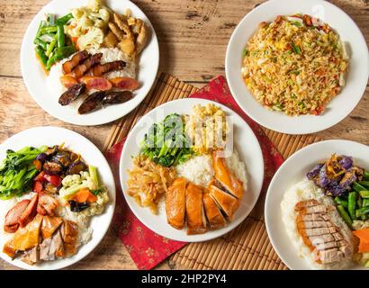 Three Treasures Ris, Char Siew Fried Ris, Lap Mee Ris im Hong Kong-Stil, Rose Chicken Rick, knusprig gebratener Schweinefleischreis mit Salat und rotem chinesischen Chili Stockfoto