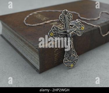 Eine Nahaufnahme einer kunstvollen antiken Rosenkranzkette neben einer alten getragenen antiken bibel auf einem isolierten Hintergrund - 3D Render Stockfoto