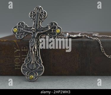 Eine Nahaufnahme einer kunstvollen antiken Rosenkranzkette neben einer alten getragenen antiken bibel auf einem isolierten Hintergrund - 3D Render Stockfoto