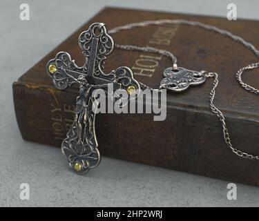 Eine Nahaufnahme einer kunstvollen antiken Rosenkranzkette neben einer alten getragenen antiken bibel auf einem isolierten Hintergrund - 3D Render Stockfoto