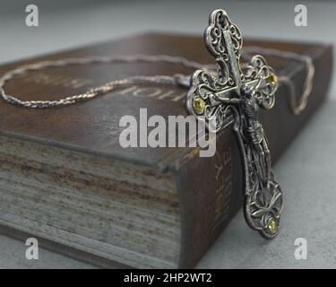 Eine Nahaufnahme einer kunstvollen antiken Rosenkranzkette neben einer alten getragenen antiken bibel auf einem isolierten Hintergrund - 3D Render Stockfoto