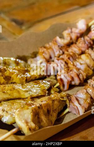 Huhn und Schweinespieße Thai Nachtmarkt Street Food in Huai Khwang Bangkok Thailand. Stockfoto