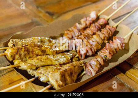 Huhn und Schweinespieße Thai Nachtmarkt Street Food in Huai Khwang Bangkok Thailand. Stockfoto