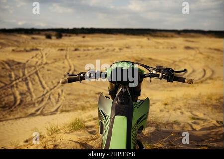 Sicht des Motocross-Fahrers auf Sandgelände. Detail Motorrad Lenkrad Nahaufnahme Stockfoto