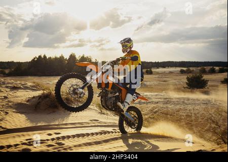 Qualifizierte professionelle Moto-Fahrer machen Stunt auf dem Motorrad. Biker machen schwierige und gefährliche Tricks in der Wüste Stockfoto