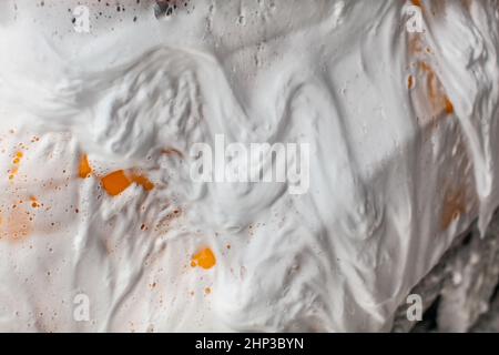 Seite der gelben Auto, bedeckt mit Shampoo Schaum, wenn in der Waschstraße gewaschen. Stockfoto