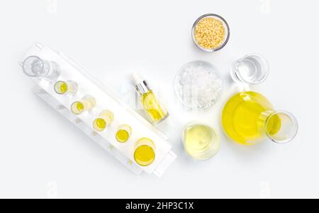 Kosmetische Chemikalien Inhaltsstoff auf weißem Labortisch. Candelilla Wachs, mikrokristallines Wachs, Gelbe kosmetische Farbe (Öl), Nickelchlorid Flüssigkeit und Stockfoto