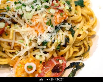 Hausgemachter Hummer Linguine auf weißem Teller serviert. Hummerfleisch, getrocknete Chilischoten und Kirschtomaten vermischen sich. Stockfoto