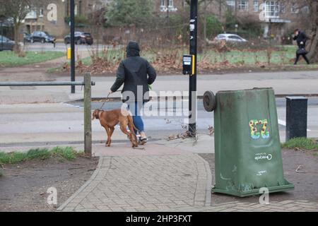 London, Großbritannien. 18. Februar 2022: London wurde vom Met Office zum Met-Alarmzentrum hinzugefügt, als der Sturm Eunice das Land durchquert. Auf Clapham Common sind nur sehr wenige Menschen draußen und viele kleine Äste sind von Bäumen herunter, und einige Bäume ganz herunter oder kippen alarmierend. Vögel hunkern mit dem Kopf in den Wind und der halbzeitweilige Jahrmarkt ist geschlossen, der Zaun ist teilweise gestürzt. Anna Watson/Alamy Live News Stockfoto