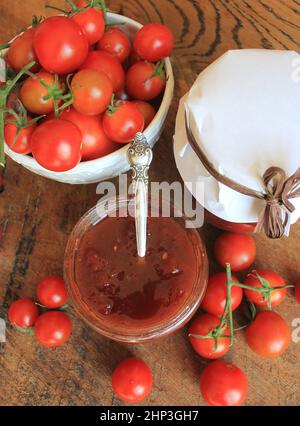 Kirschtomate und Chili Marmelade konserviert in einem Glas. Stockfoto