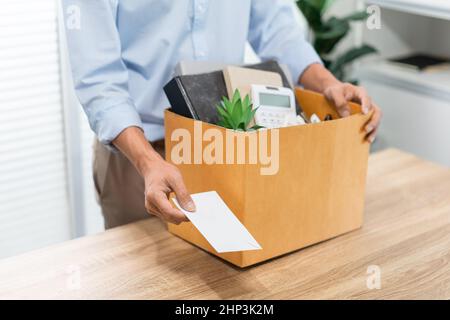 Resignation Konzept der männliche Offizier steht, legt seine Kiste seiner gehört auf den Schreibtisch und übergibt den weißen Brief an jemanden. Stockfoto